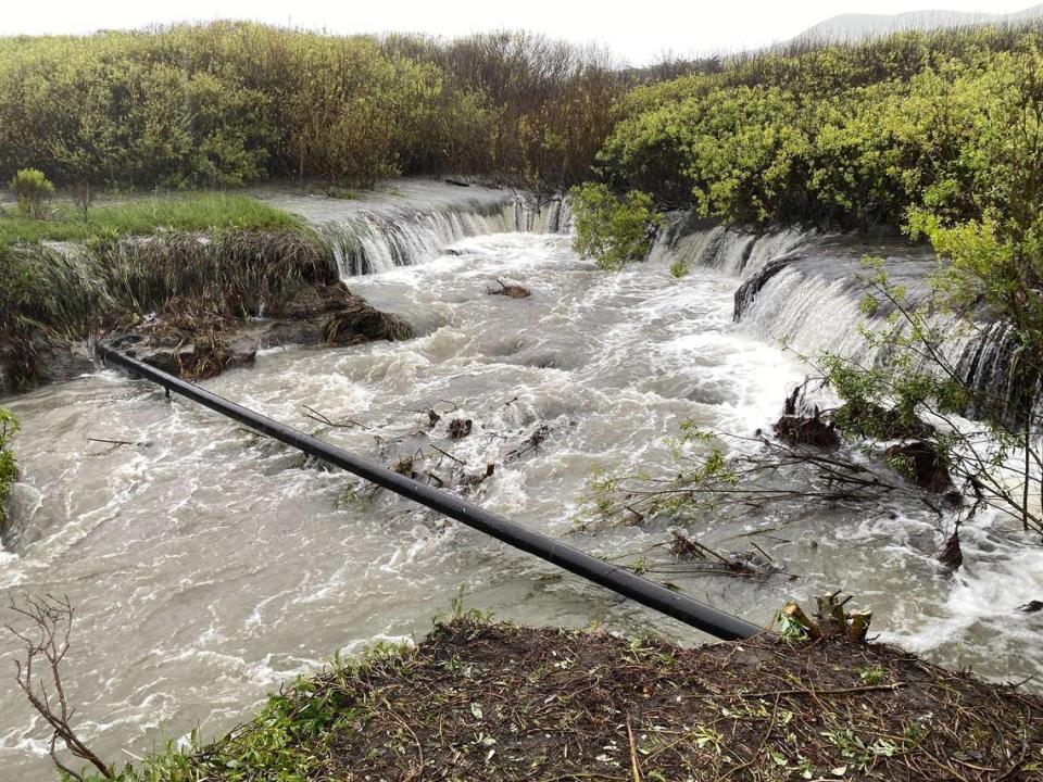 Water rushes under an exposed gas main in Old Creek near Studio Drive in Cayucos on Tuesday, March 14, 2023. David Middlecamp/dmiddlecamp@thetribunenews.com