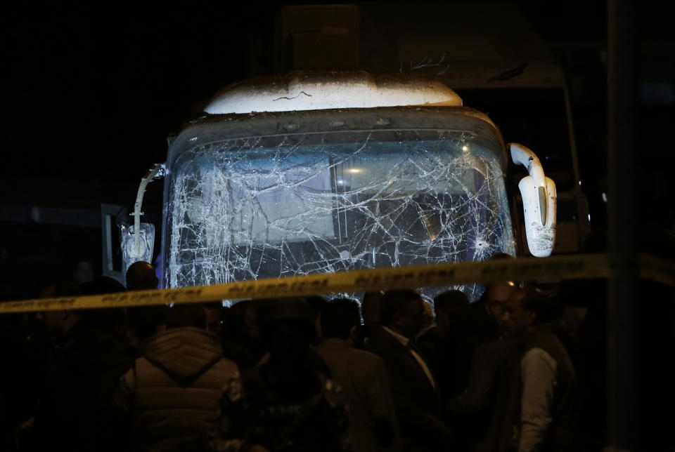 Security forces stand near a tourist bus after a roadside bomb in an area near the Giza Pyramids in Cairo, Egypt, Friday, Dec. 28, 2018. Egypt's Interior Ministry said in a statement that two Vietnamese tourists were killed and others wounded, in the incident.(AP Photo/Nariman El-Mofty)