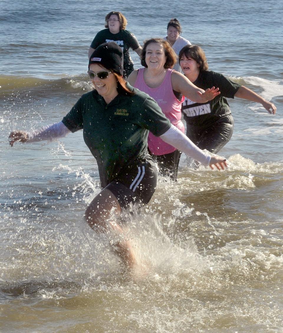 Principal Megan Kicklighter heads to shore after she and others from Haven Elementary plunged into a very cold ocean near the Tybee Pier.