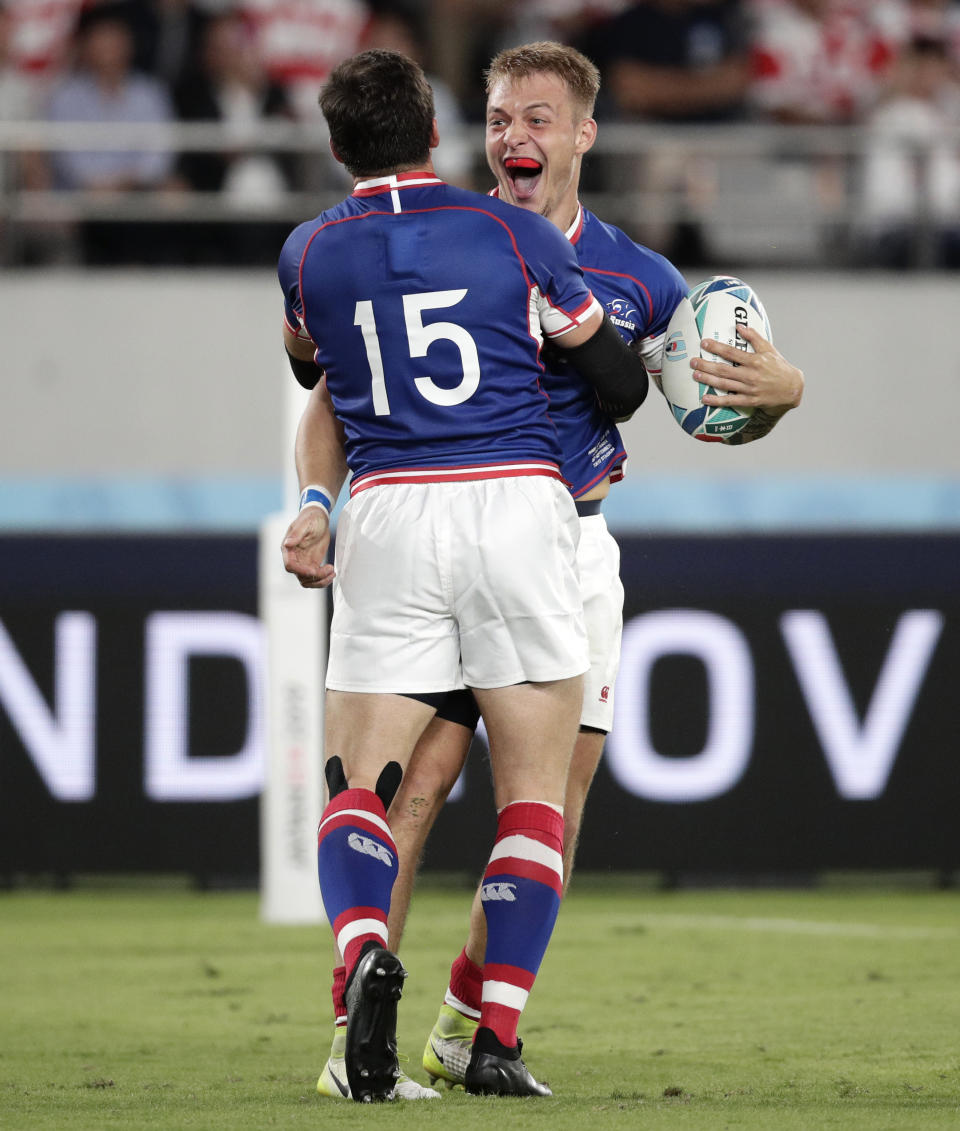 Russia's Kirill Golosnitskiy, right, celebrates with teammate Vasily Artemyev after scoring a try during the Rugby World Cup Pool A game at Tokyo Stadium between Russia and Japan in Tokyo, Japan, Friday, Sept. 20, 2019. (AP Photo/Jae Hong)