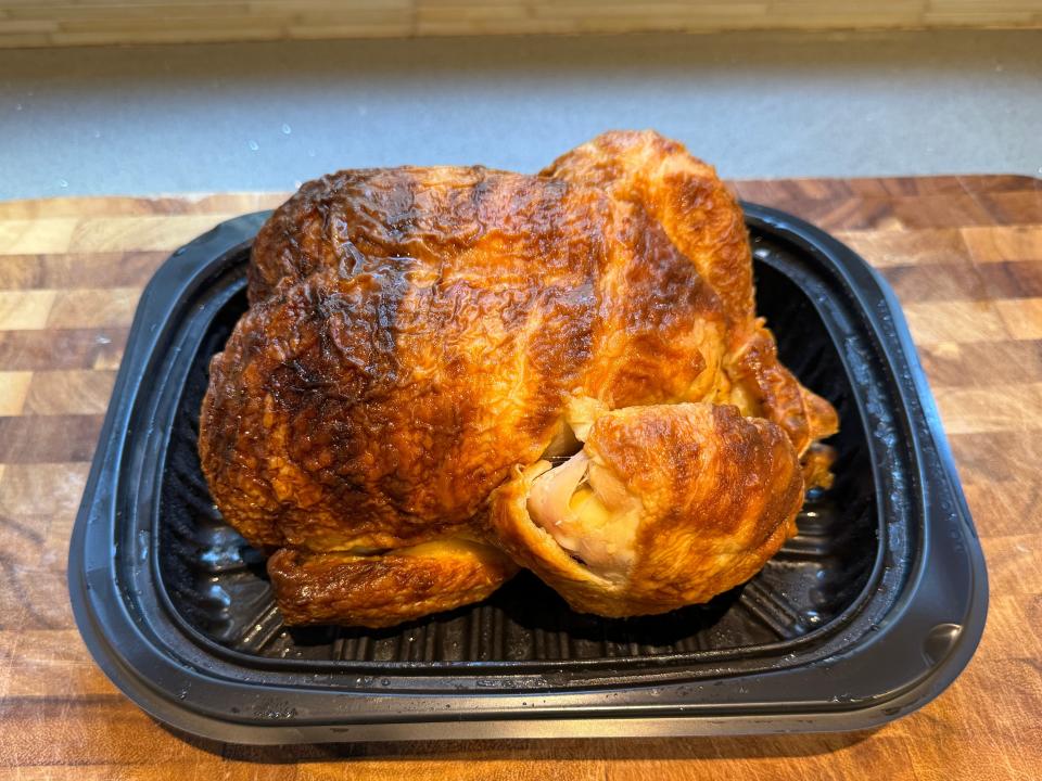 Rotisserie chicken from Costco in plastic lid on cutting board