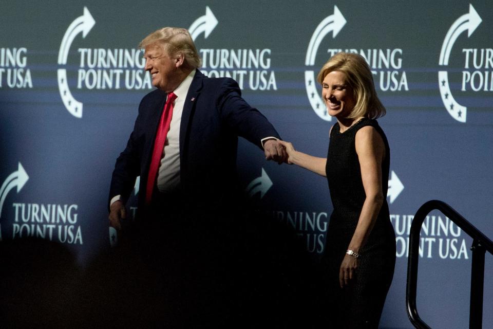 President Donald Trump invites radio personality Laura Ingraham up on stage during his speech at the Turning Point USA Student Action Summit in December 2019.