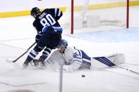 Winnipeg Jets' Pierre-Luc Dubois (80) collides with Toronto Maple Leafs goaltender Joseph Woll (60) as he leaves the crease after the puck during the third period of NHL hockey game action in Winnipeg, Manitoba, Sunday, Dec. 5, 2021. (Fred Greenslade/The Canadian Press via AP)