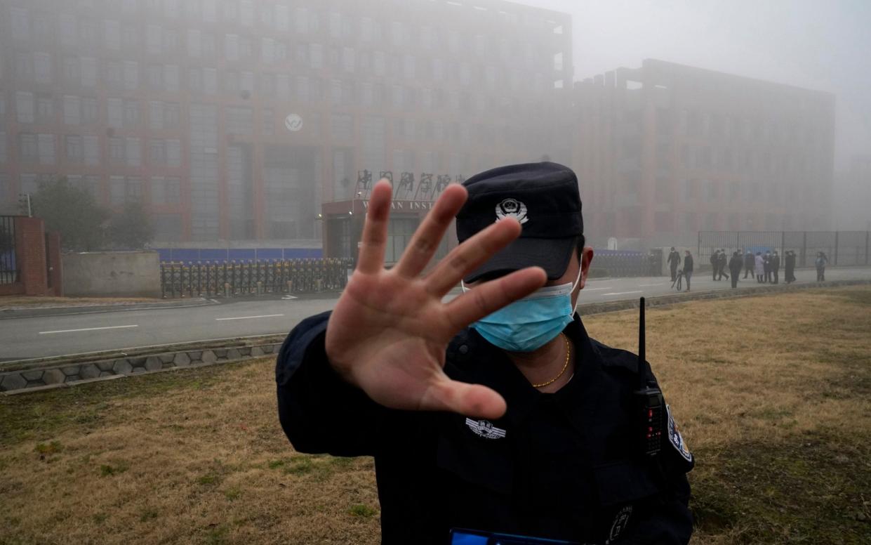  A security person moves journalists away from the Wuhan Institute of Virology after a World Health Organization team arrived for a field visit in Wuhan in China's Hubei province on Feb. 3, 2021 - AP/Ng Han Guan 