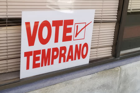 A sign written in Spanish and pointing to an early voting station is seen in Dodge City, Kansas, U.S. October 26, 2018. REUTERS/John Whitesides