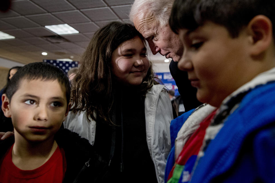 Democratic presidential candidate former Vice President Joe Biden touches foreheads with Isabel Krogmeier, 11, after she and her brothers Victor, 7, left, and Elijah, 10, right, took a campaign photo with Biden campaign stop at a Quality Inn, Friday, Jan. 31, 2020, in Fort Madison, Iowa. According to Isabel, Biden put a five dollar bill in her hand and told them to "spend it and give everyone ice cream." (AP Photo/Andrew Harnik)