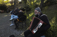 A musician performs in a public garden, in Ankara, Turkey, Friday, Nov. 27, 2020. When Turkey changed the way it reports daily COVID-19 infections, it confirmed what medical groups and opposition parties have long suspected — that the country is faced with an alarming surge of cases that is fast exhausting the Turkish health system. The official daily COVID-19 deaths have also steadily risen to record numbers in a reversal of fortune for the country that had been praised for managing to keep fatalities low. With the new data, the country jumped from being one of the least-affected countries in Europe to one of the worst-hit.(AP Photo/Burhan Ozbilici)