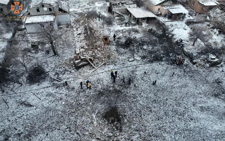 A missile crater is seen next to a destroyed house in Dnipropetrovsk