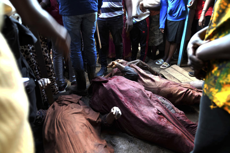 Residents gather around the covered bodies of women retrieved from a house, after heavy rain in the Mathare slum of Nairobi, Kenya, Wednesday, April 24, 2024. Heavy rains pounding different parts of Kenya have led to dozens of deaths and the displacement of tens of thousands of people, according to the U.N., citing the Red Cross. (AP Photo/Brian Inganga)