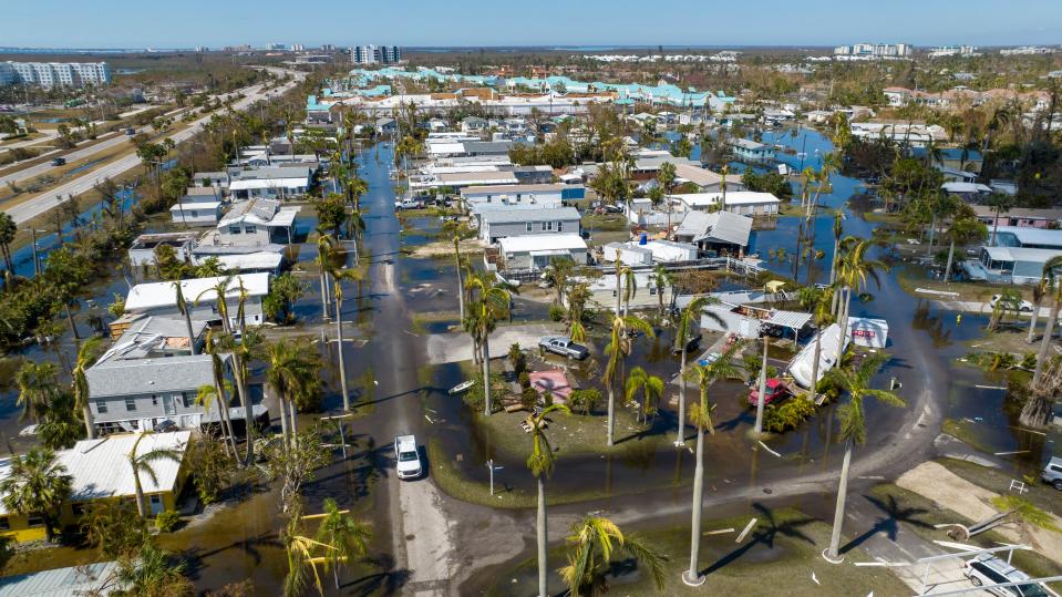 FILE - Water floods a damaged trailer park in Fort Myers, Fla., on Saturday, Oct. 1, 2022, after Hurricane Ian passed by the area. Hurricane Ian has resulted in at least 79 people confirmed dead, including 71 in Florida, as hundreds of thousands of people wait for power to be restored. (AP Photo/Steve Helber, File)