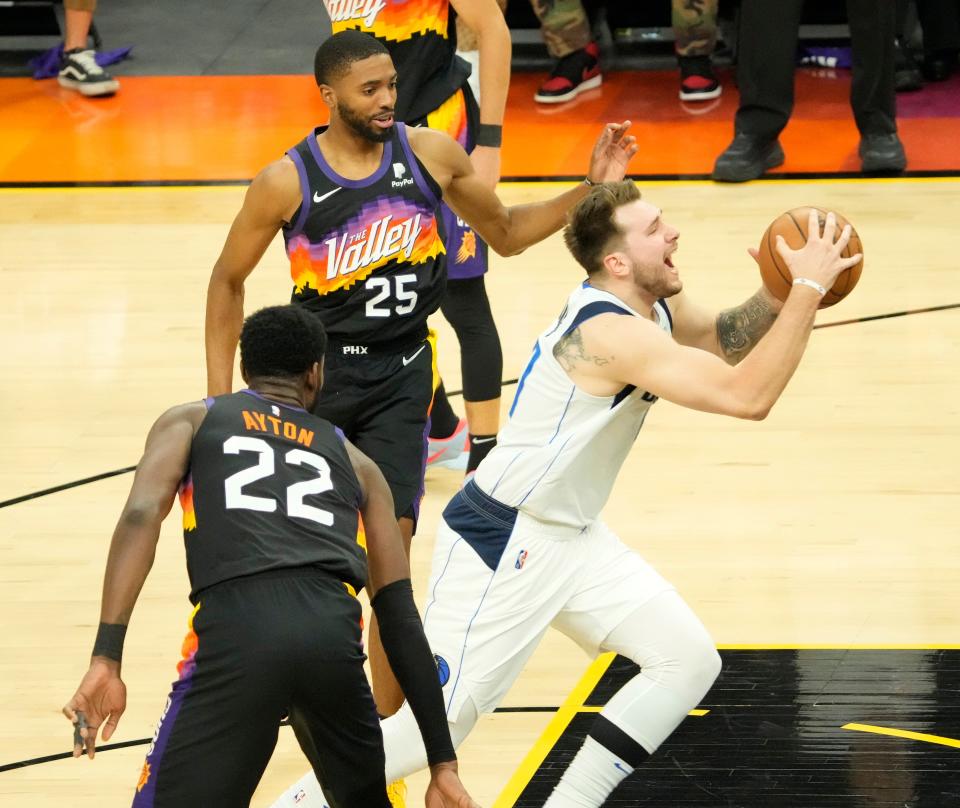 May 15, 2022; Phoenix, Ariz.. U.S.; Dallas Mavericks guard Luka Doncic (77) splits the defense of Phoenix Suns center Deandre Ayton (22) and forward Mikal Bridges (25) during game 7 of the Western Conference semifinals at Footprint Center. Mandatory Credit: Michael Chow-Arizona Republic