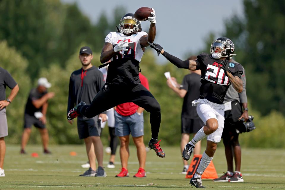 Atlanta Falcons running back Cordarrelle Patterson (84) makes a one-handed catch against cornerback Teez Tabor (20) during NFL football training camp, Tuesday, Aug. 2, 2022, in Flowery Branch, Ga. (Jason Getz/Atlanta Journal-Constitution via AP)