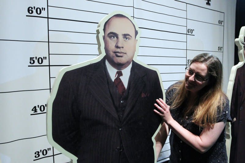 Amanda Bailey with the Missouri History Museum adjusts a cutout figure of Al Capone as final preperations are made for an exhibit in 2014. On February 14, 1929, in what became known as the "St. Valentine's Day Massacre," gunmen believed to be working for Capone killed seven members of the rival George "Bugs" Moran gang in a Chicago garage. File Photo by Bill Greenblatt/UPI