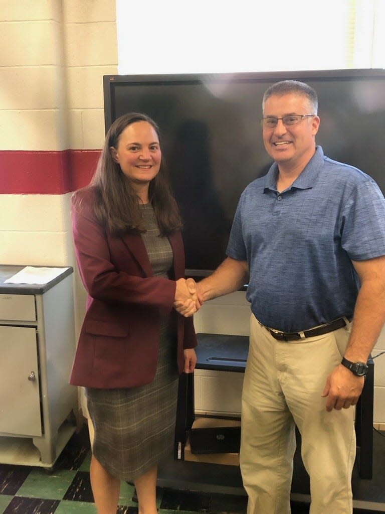 Tracy Konik is congratulated by Board President Doug Hamman on her new position as treasurer of the Plymouth-Shiloh Local School District.