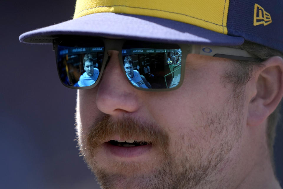 Milwaukee Brewers' Tyler Black is reflected in the glasses of hitting coach Connor Dawson as he listens to Dawson in the dugout during the third inning of a baseball game against the Chicago Cubs Friday, May 3, 2024, in Chicago. (AP Photo/Charles Rex Arbogast)