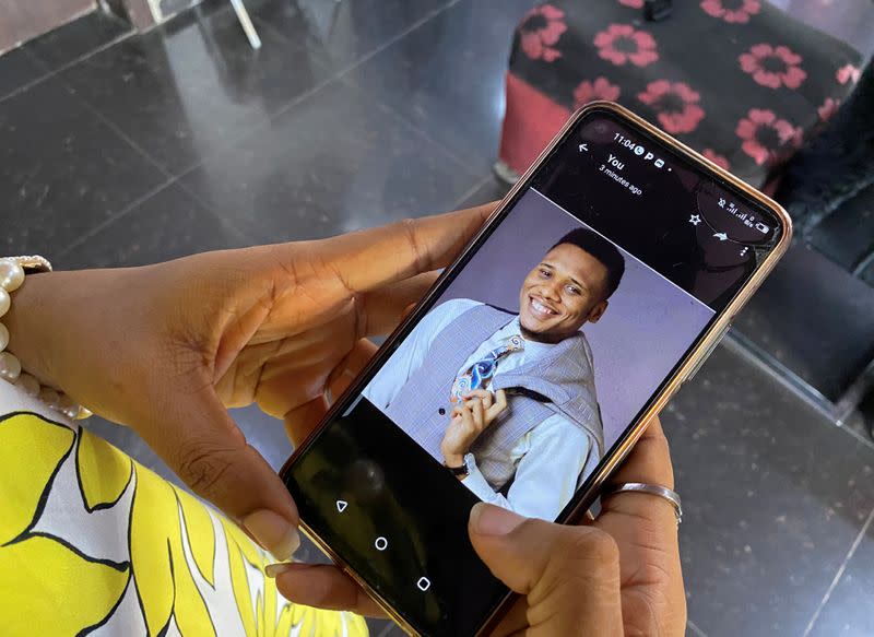 Onomene Adene shows a picture of her brother on a mobile phone during an interview with Reuters in Lagos