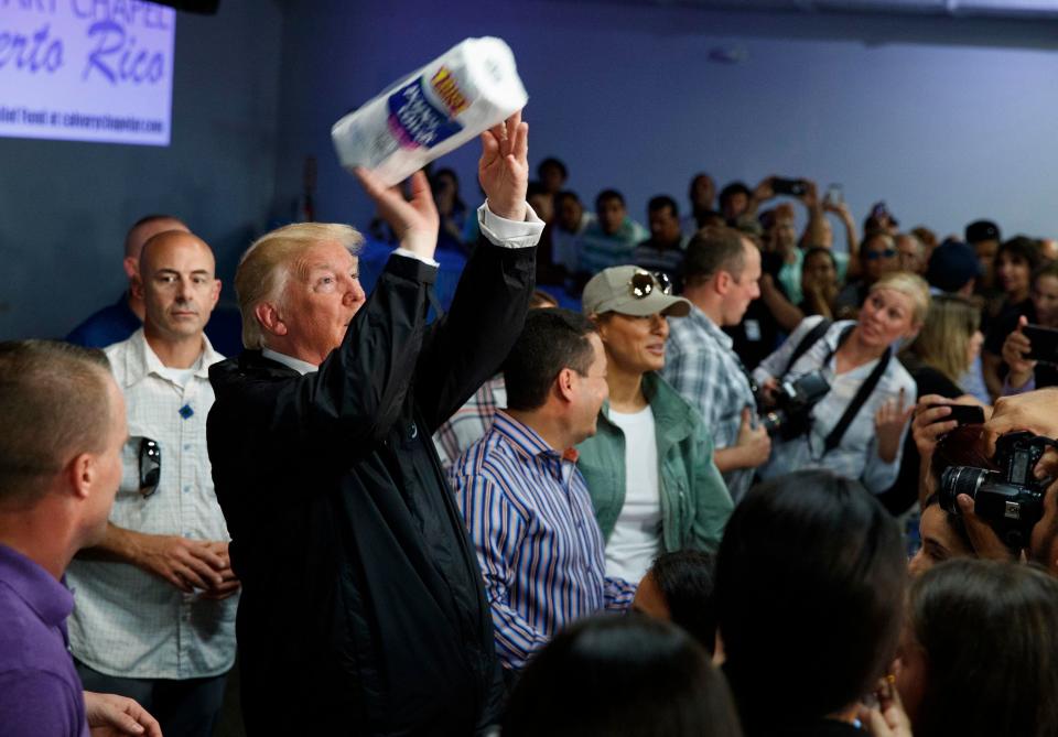 President Donald Trump tosses paper towels into a crowd at Calvary Chapel in Guaynabo, Puerto Rico on Oct. 3, 2017.