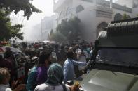 Rescue workers and people gather near the site after a Pakistan International Airlines flight crashed in a residential neighbourhood in Karachi on May 22, 2020. - A Pakistan passenger plane with more than 100 people believed to be on board crashed in the southern city of Karachi on May 22, the country's aviation authority said. (Photo by Asif HASSAN / AFP) (Photo by ASIF HASSAN/AFP via Getty Images)