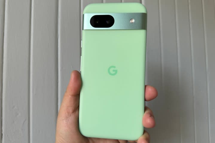 Someone holding the green Aloe Google Pixel 8a.