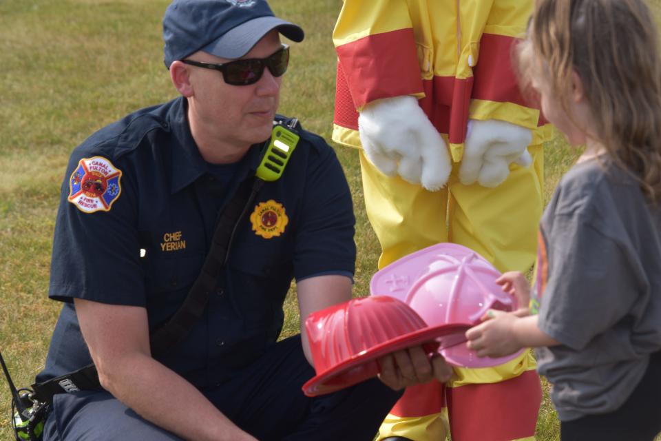 Lawrence Fire Chief Shawn Yerian presents red and pink fire hat options during the township's Community Day event in 2023. The township plans to host this year's Community Day on June 8.