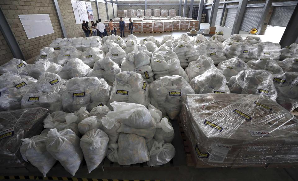 En esta foto del 19 de febrero del 2019, periodistas y miembros del gobierno colombiano visitan un almacén donde está guardada la ayuda humanitaria estadounidense para Venezuela cerca del Puente Internacional Tienditas en Cúcuta, Colombia, en la frontera con Venezuela. (AP Foto/Fernando Vergara)