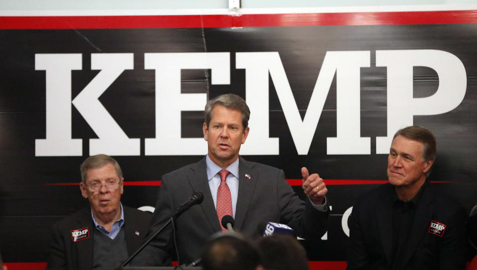 FILE - Then-Georgia Republican gubernatorial candidate Brian Kemp, center, speaks to volunteers as Sen. Johnny Isakson (R-Ga), left, and Sen. David Perdue (R-Ga) look on during a stop at a campaign office, Nov. 5, 2018, in Atlanta. Perdue will challenge Gov. Kemp for governor, he announced Monday, Dec, 6, 2021 setting up a bitter 2022 Republican primary fight while Democrat Stacey Abrams is likely to await the winner. (AP Photo/John Bazemore, File)