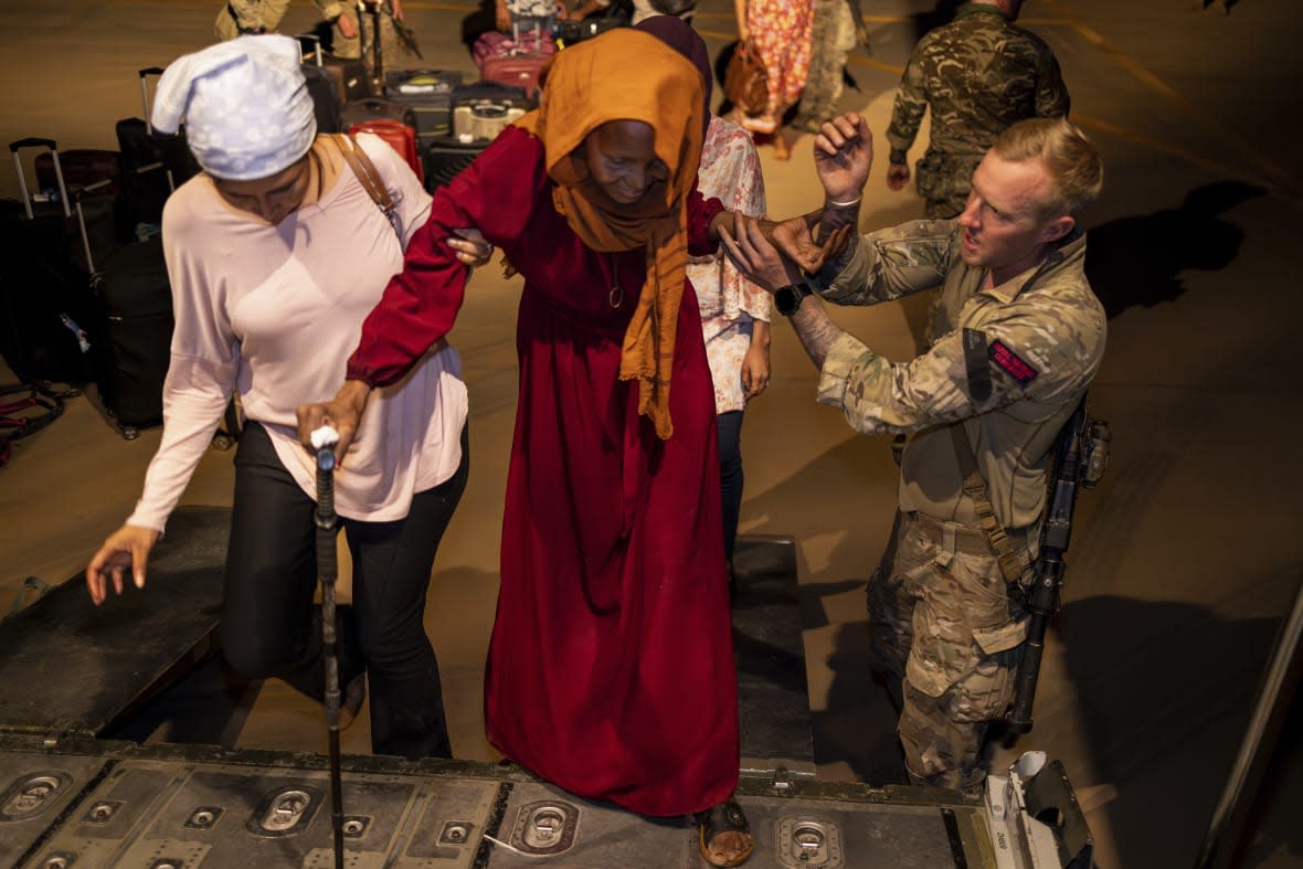 In this handout image, provided by the UK Ministry of Defence, on Wednesday, April 26, 2023 British Nationals seen here boarding an RAF aircraft in Akrotiri, Cyprus, after being evacuated from Sudan. (LPhot Mark Johnson/UK Ministry of Defence via AP)