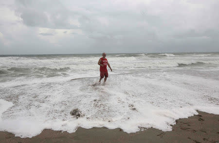 A man looks out at the sea as while hurricane Matthew approaches in Melbourne, Florida, U.S. October 6, 2016. REUTERS/Henry Romero