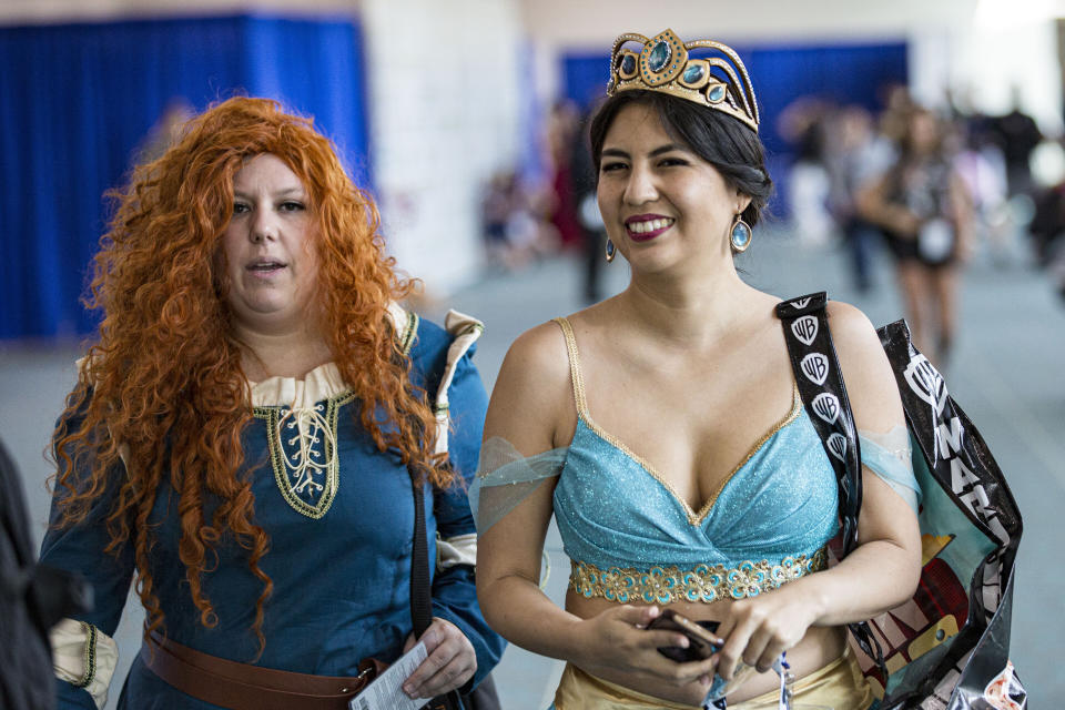 Cosplayers dressed as Princess Merida, left, and Princess Jasmine.