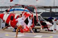 Artists perform in front of a Russian multi-purpose Ansat helicopter during the 53rd International Paris Air Show at Le Bourget Airport near Paris