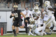 Central Florida quarterback John Rhys Plumlee (10) rushes for a 28-yard touchdown past Georgia Tech defensive backs LaMiles Brooks (20), Myles Sims (0) and Zamari Walton, right, during the second half of an NCAA college football game, Saturday, Sept. 24, 2022, in Orlando, Fla. (AP Photo/Phelan M. Ebenhack)