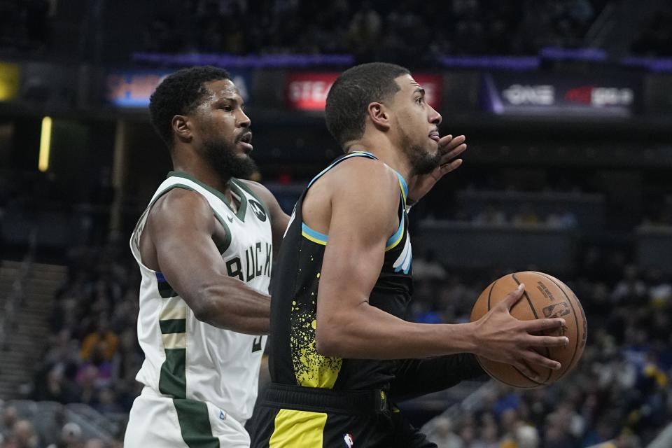 Indiana Pacers' Tyrese Haliburton, right, goes to the basket against Milwaukee Bucks' Malik Beasley during the first half of an NBA basketball game, Thursday, Nov. 9, 2023, in Indianapolis. (AP Photo/Darron Cummings)