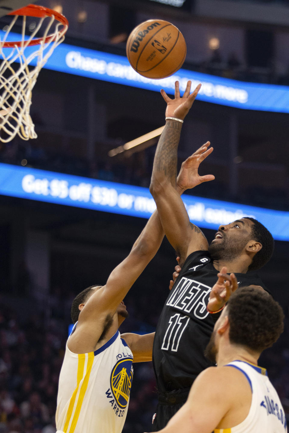 Brooklyn Nets guard Kyrie Irving (11) shoots over Golden State Warriors guard Jordan Poole during the first quarter of an NBA basketball game, Sunday, Jan. 22, 2023, in San Francisco. (AP Photo/D. Ross Cameron)