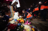 Sierra Rogers, who called Tyre Nichols her best friend, adjusts items in a memorial, after a prayer gathering at the site where he was beaten by Memphis police officers, and later died from his injuries, in Memphis, Tenn., Monday, Jan. 30, 2023. (AP Photo/Gerald Herbert)