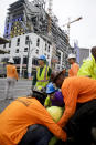 Workers are helped after a large portion of a hotel under construction suddenly collapsed in New Orleans on Saturday, Oct. 12, 2019. Several construction workers had to run to safety as the Hard Rock Hotel, which has been under construction for the last several months, came crashing down. It was not immediately clear what caused the collapse or if anyone was injured. (Scott Threlkeld/The Advocate via AP)
