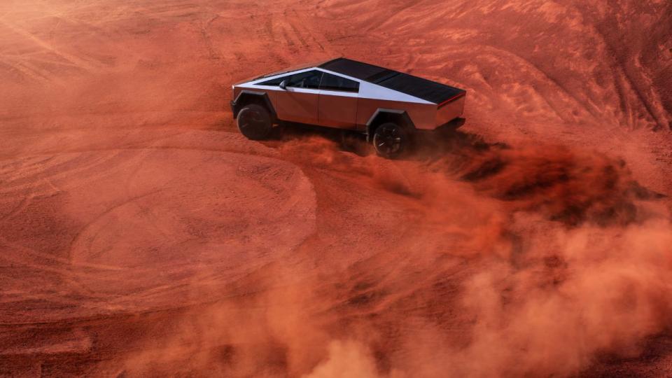 tesla cybertruck driving through a desert