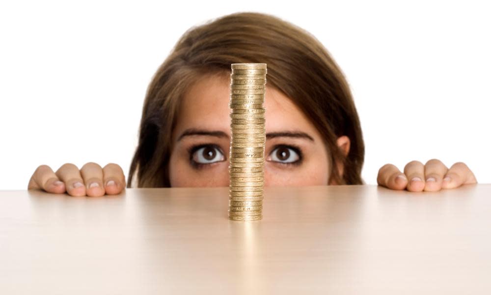 A teenage girl watching a stack of Pound coins