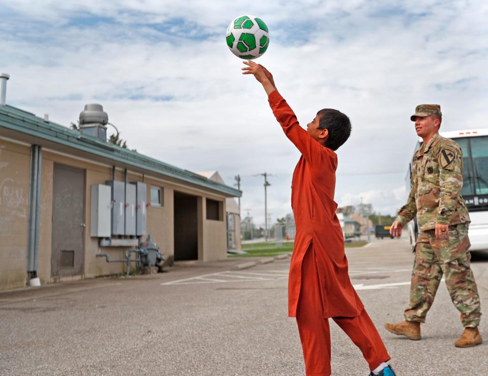 Children play volleyball with soldiers and others outside an Operation Allies Welcome community building Thursday, Oct. 14, 2021 at Camp Atterbury in Edinburgh, IN.