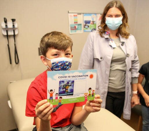 Maxwell Bauer, son of Dr. Elizabeth Bauer, proudly displays his COVID-19 vaccine certificate with his mom present to watch. Photo: Courtesy Sanford Health