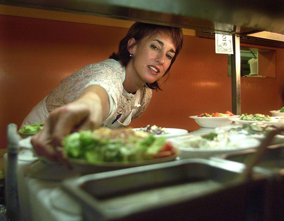 Rita DeVore, owner of Shranks Cafeteria & Catering Co., arranges salads in her restaurant in 1999.