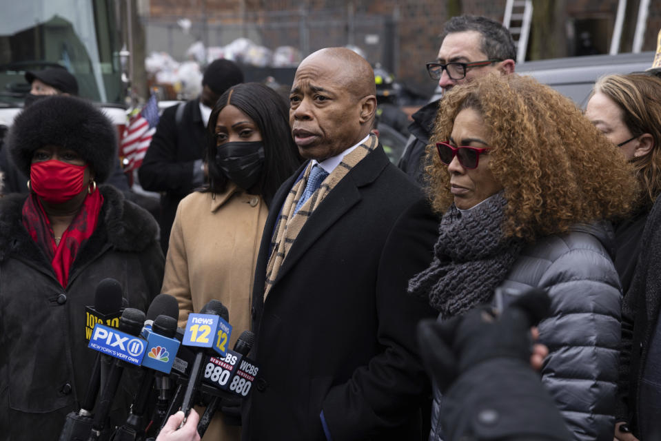 New York City Mayor Eric Adams, middle, speaks during a news conference outside an apartment building where a deadly fire occurred in the Bronx on Sunday, Jan. 9, 2022, in New York. (AP Photo/Yuki Iwamura)