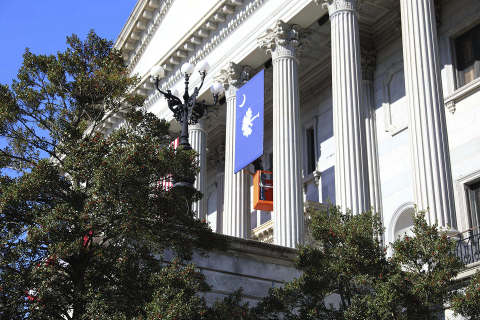 A worker prepares a South Carolina flag on the Statehouse to prepare the day before Gov. Henry McMaster's inauguration on Tuesday, Jan. 10, 2023, in Columbia, S.C. (AP Photo/Jeffrey Collins)