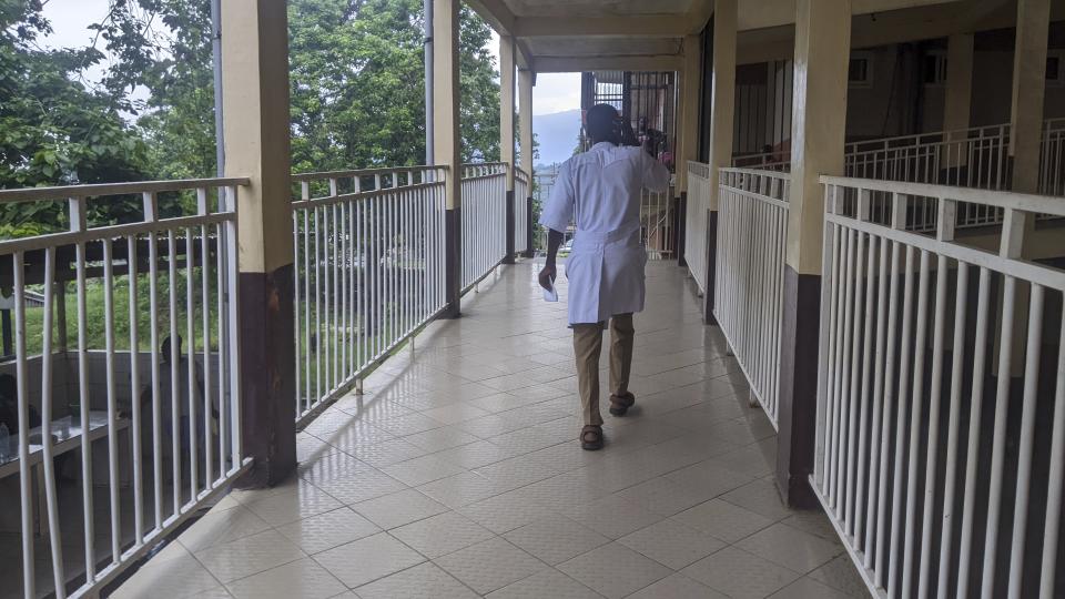 Heath worker walks in the Mbingo Baptist Hospital in Mutengene, Cameroon, Tuesday May 21, 2024. The state of health care in Cameroon is a source of growing concern, with thousands of doctors and nurses leaving the country for better paying jobs in Canada. While the central African country has one of the lowest number of health workers per capita in the world, salaries and recruitment in the medical field remains extremely low. (AP Photo/Angel Ngwe)