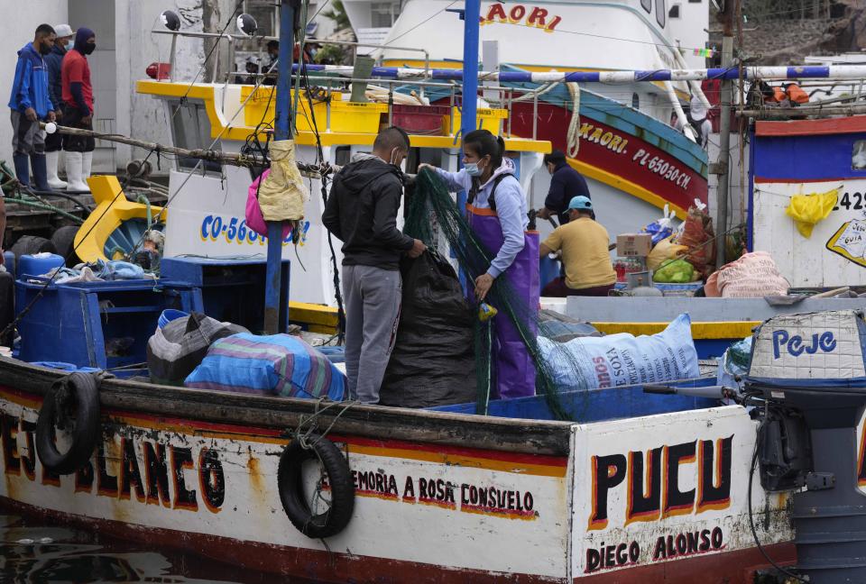 Fishermen prepare their boats before going out to sea in Pucusana, Peru, Monday, Sept. 20, 2021. To compete with the Chinese, the local fishermen of Pucusana assume ever-greater risks, venturing farther out from home and spending as much as a week at sea to haul in what they used to catch in a single day close to shore. (AP Photo/Martin Mejia)