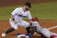 Miami Marlins third baseman Jon Berti, left, is unable to tag out Philadelphia Phillies' Roman Quinn (24) as Quinn slides into third base during the third inning of a baseball game, Wednesday, May 26, 2021, in Miami. (AP Photo/Wilfredo Lee)