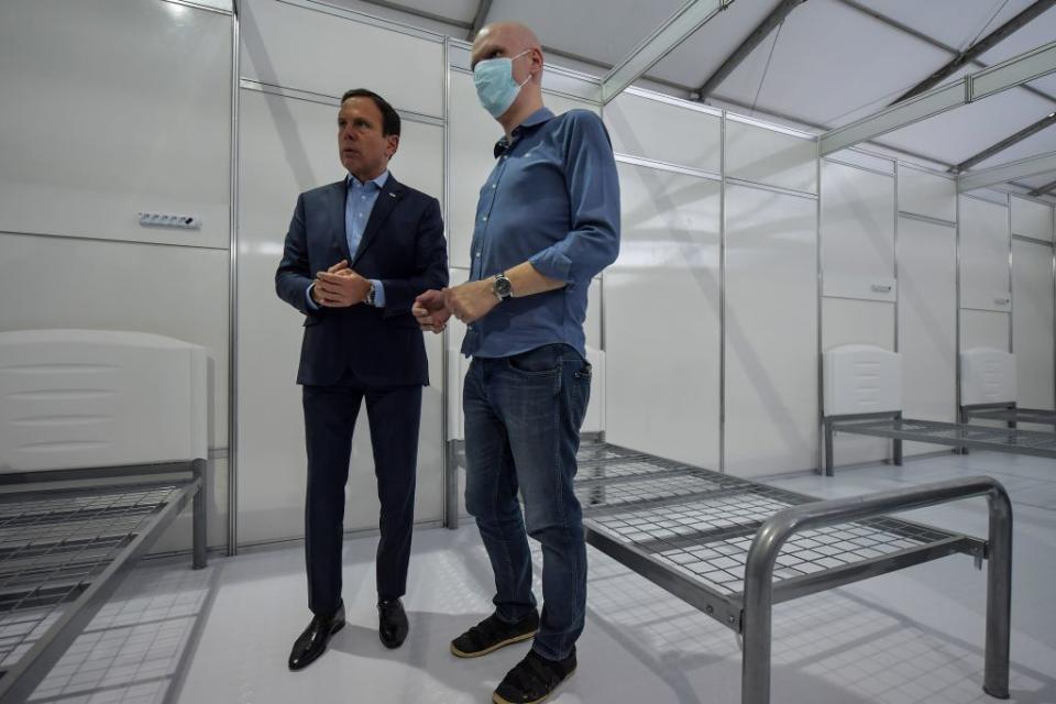 Sao Paulo state Governor Joao Doria (L) and Sao Paulo city Mayor Bruno Covas (R) visit a field hospital set up for coronavirus patients at Pacaembu stadium, in Sao Paulo, Brazil on March 27, 2020 | Nelson Almeida—AFP via Getty Images