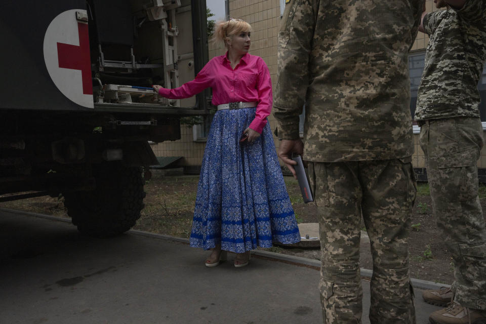 Medic volunteer Nataliia Voronkova, left, speaks to soldiers as she delivers medical aid to a hospital, in Kurakhove, Donetsk region, eastern Ukraine, Thursday, July 21, 2022. Voronkova has dedicated her life to aid distribution and tactical medical training for soldiers and paramedics, working on front line of the Donetsk region since the war began in 2014. (AP Photo/Nariman El-Mofty)