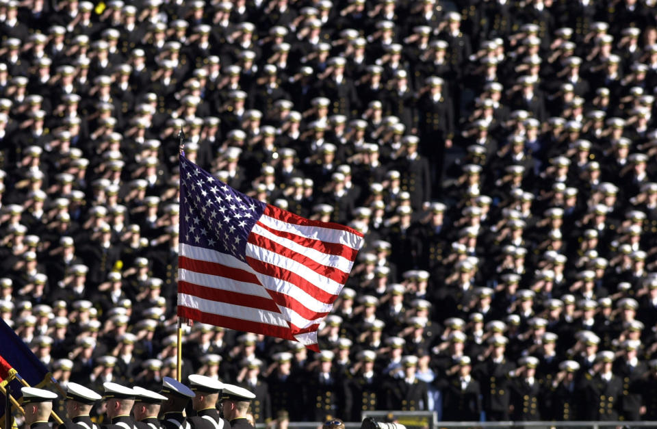 FILE - In this Dec. 1, 2001, file photo, the American flag flies with a background of Navy midshipmen during the national anthem at the 102nd Army Navy NCAA college football game in Philadelphia. Twenty years later, former Army football coach Todd Berry still gets choked up thinking about that Sept. 11, 2001, day and the terrorist attacks carried out not only on the twin towers at the World Trade Center but at the Pentagon, and in a field in rural Pennsylvania. (AP Photo/Chris Gardner, File)