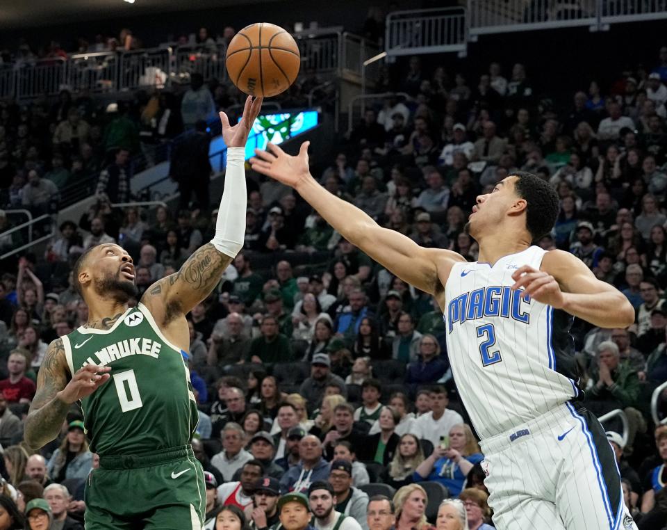 Milwaukee Bucks guard Damian Lillard outrebounds Orlando Magic guard Caleb Houstan during the first half of their game Wednesday, April 10, 2024, at Fiserv Forum in Milwaukee.