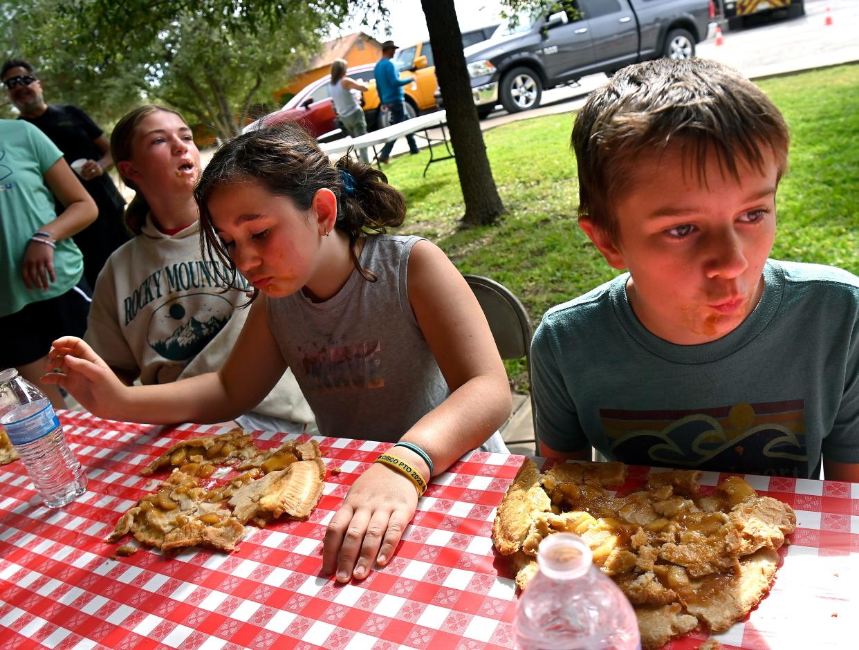 Maggie Hogue, 11, looks to see who had finished first in Saturday’s pie eating contest in Cisco as 11-year-old Harper Hutton, center, and Hank Doty, 10, begin to realize they’ve reached their limits. The annual Pie Fest, featuring the eating contest, bake-off, and vendors attracted hundreds to the Eastland County city.